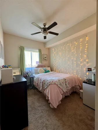 a spacious bedroom with a bed a table and large window