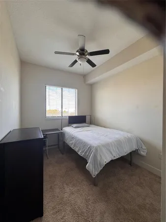 a spacious bedroom with a bed and a chandelier
