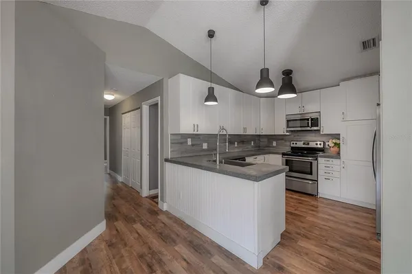 a kitchen with stainless steel appliances granite countertop a sink and a refrigerator