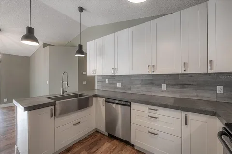 a kitchen with white cabinets stainless steel appliances and sink