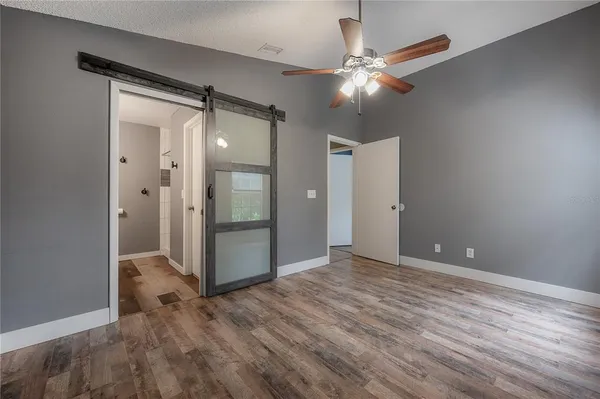 an empty room with wooden floor and mirror