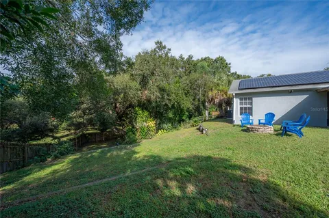 a view of a house with a backyard and a tree