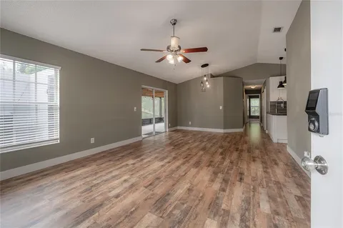 a view of a livingroom with a chandelier fan and a kitchen