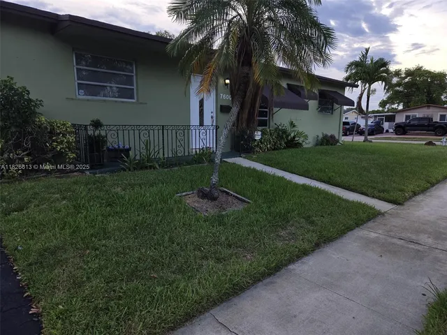 a house with green field in front of it