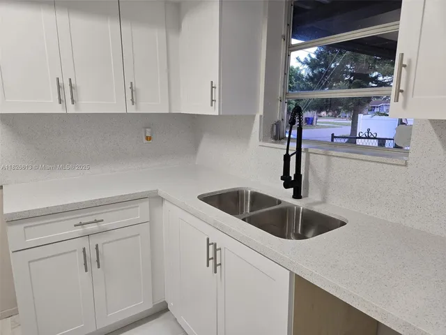 a kitchen with white cabinets and a sink