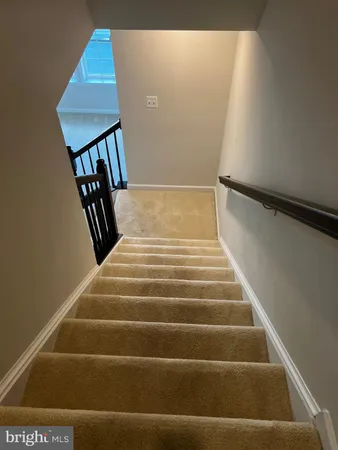 a view of staircase with railing and a rug