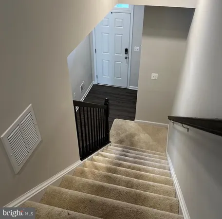 a view of a hallway with wooden floor and closet area