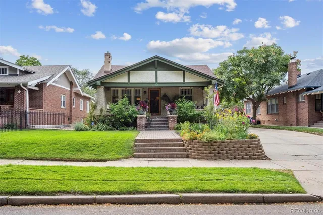 a front view of a house with a garden and yard