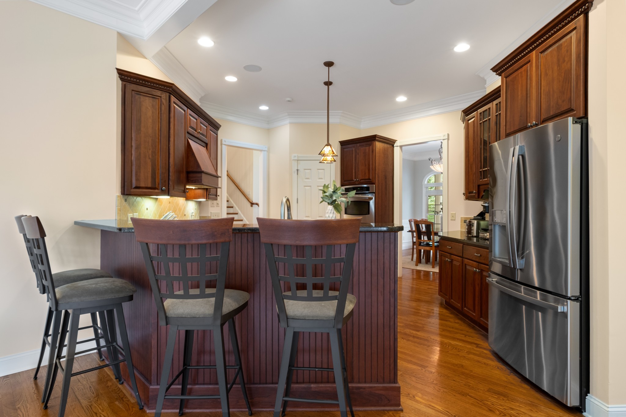 424 Sandcastle Road Franklin, TN 37069 - Photo 20 of 65 a kitchen with stainless steel appliances kitchen island granite countertop a refrigerator a stove a kitchen island a dining table and chairs with wooden floor