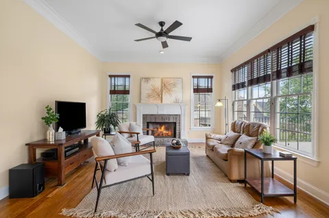 a living room with furniture a fireplace and a chandelier