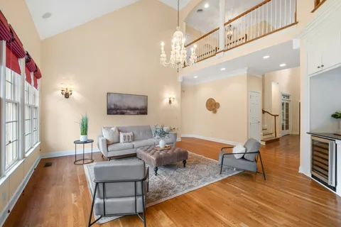 a living room with furniture a fireplace and a chandelier