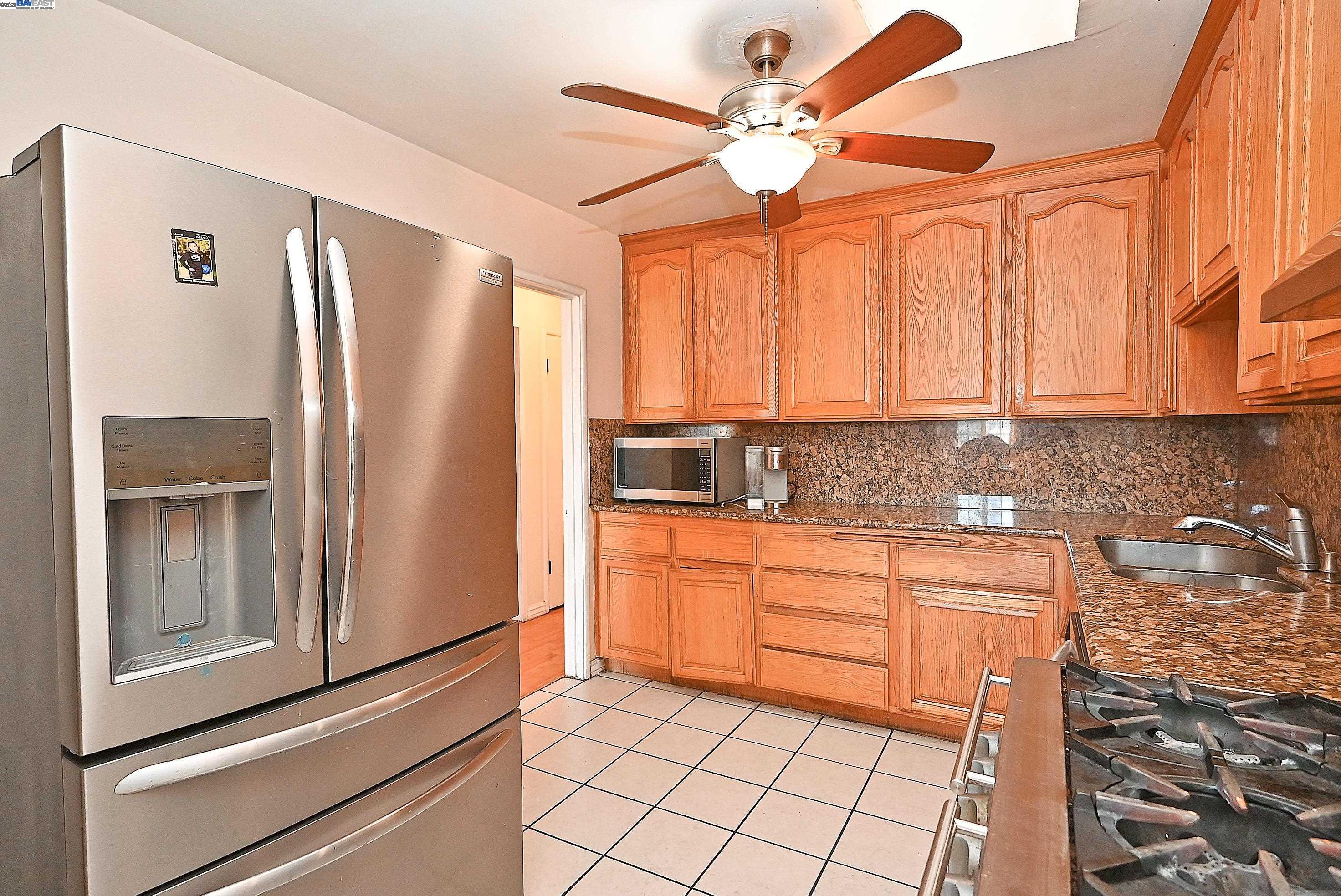 19092 Ricardo Avenue San Lorenzo, CA 94541 - Photo 12 of 29 a kitchen with stainless steel appliances granite countertop a refrigerator a sink and white cabinets