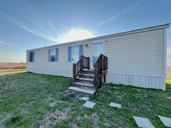 a view of a house with backyard and wooden fence