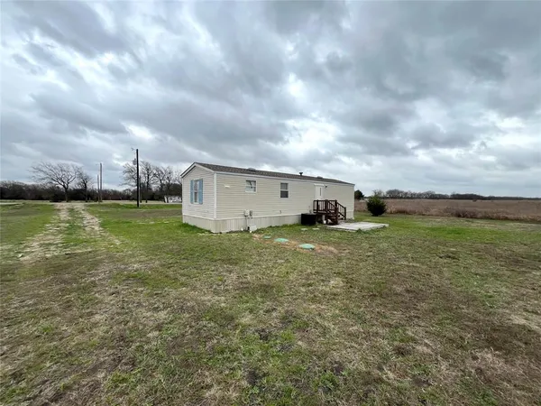 a view of a big yard with table and chairs next to a yard