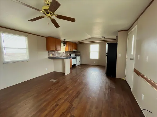 a view of a kitchen with a ceiling fan hardwood floor and a ceiling fan