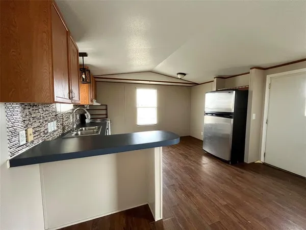 a kitchen with granite countertop a refrigerator and a sink