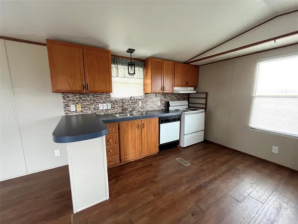 a kitchen with a sink a stove a microwave and cabinets