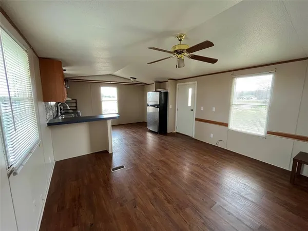 a view of a room with wooden floor and windows