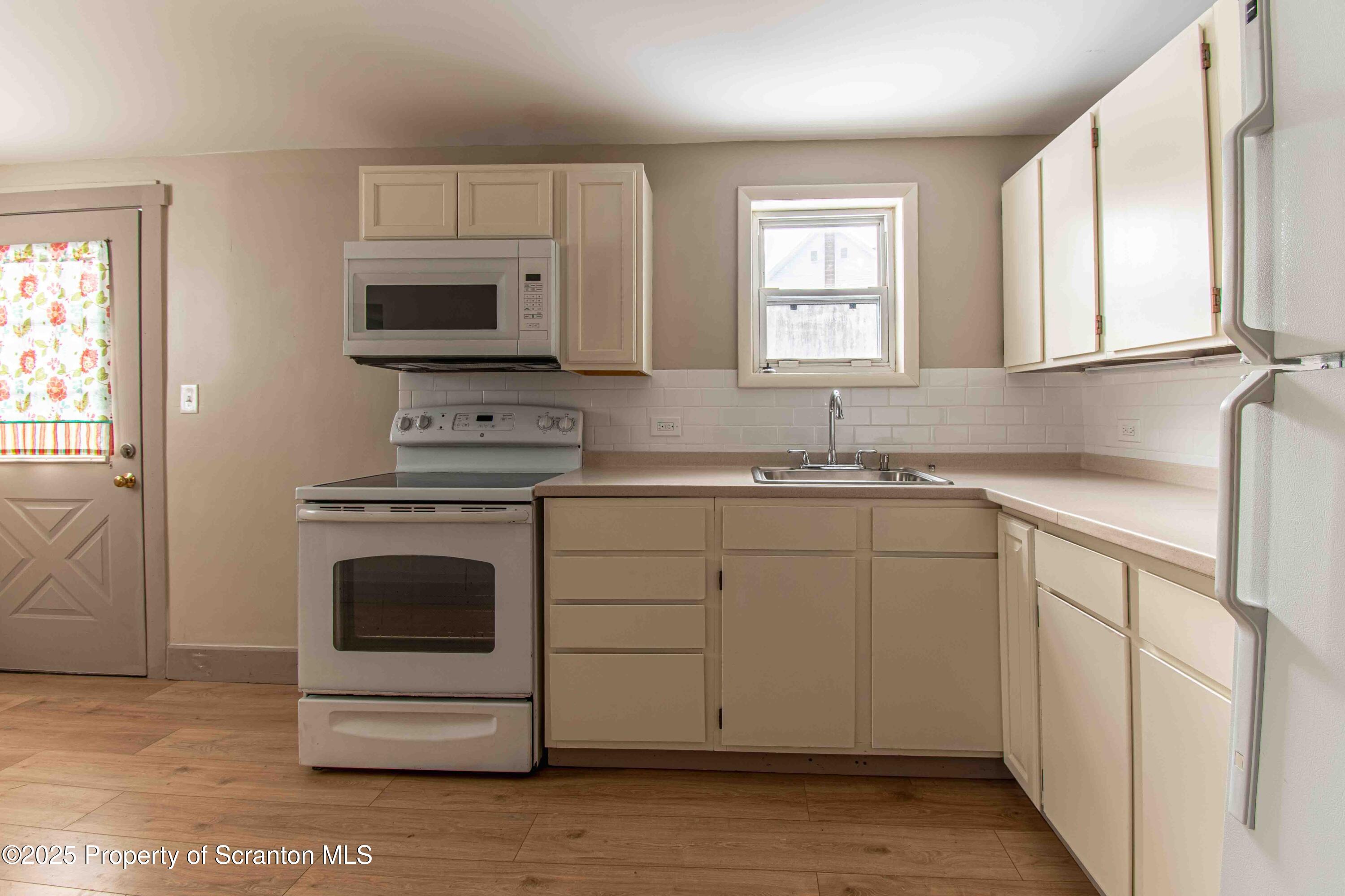 a kitchen with white cabinets sink and stainless steel appliances