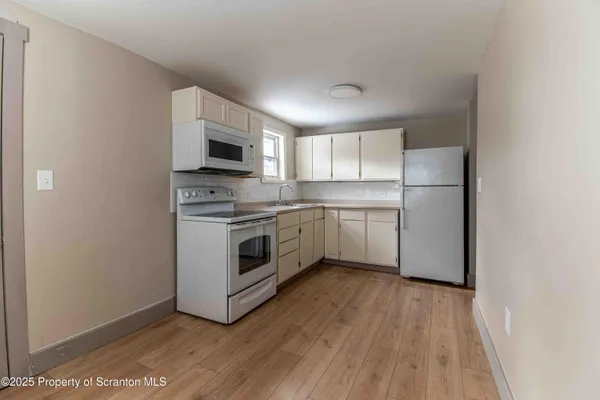a kitchen with a white stove top oven and refrigerator