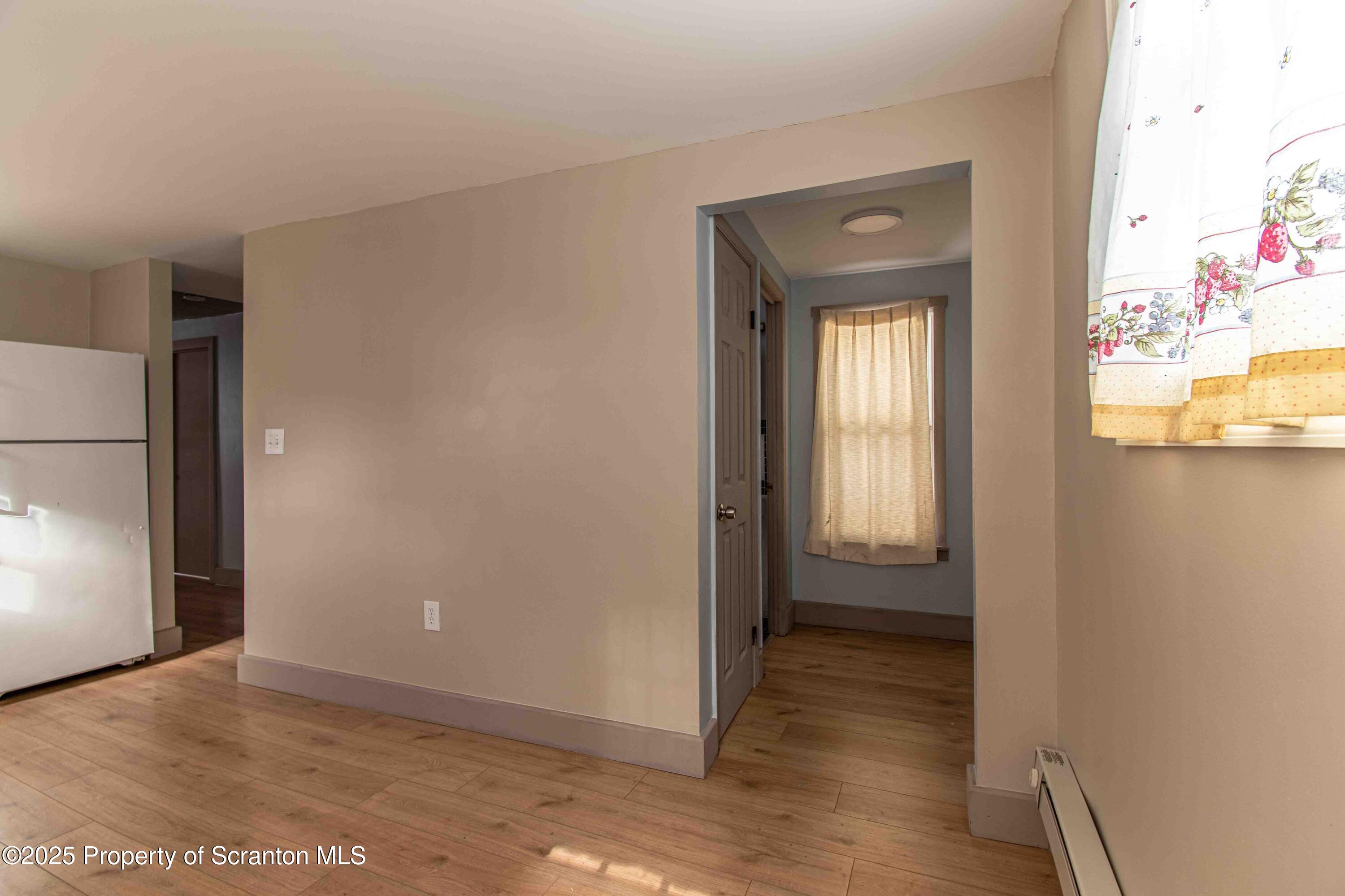 540 North Main Street Simpson, PA 18407 - Photo 3 of 17 a view of a hallway with wooden floor and a living room