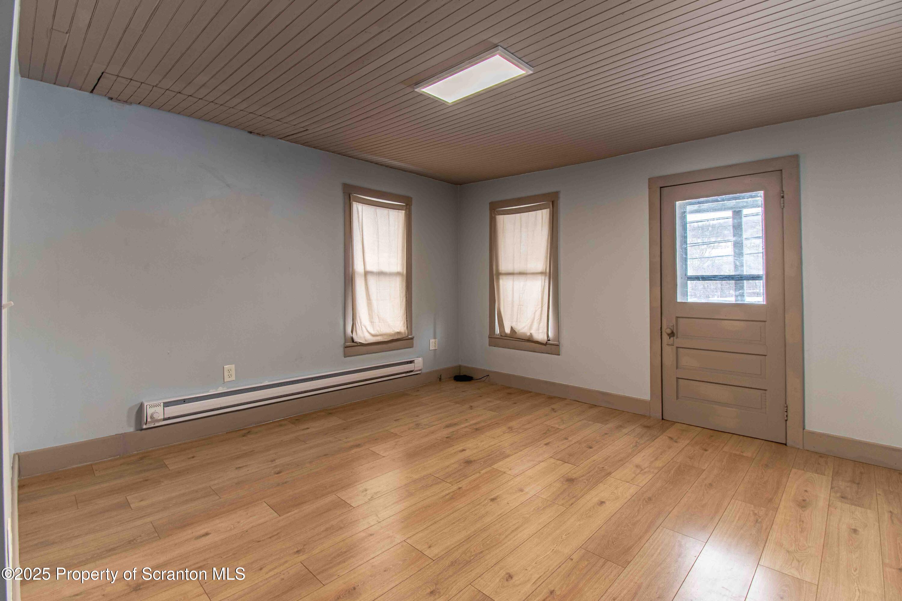 540 North Main Street Simpson, PA 18407 - Photo 6 of 17 an empty room with wooden floor and windows