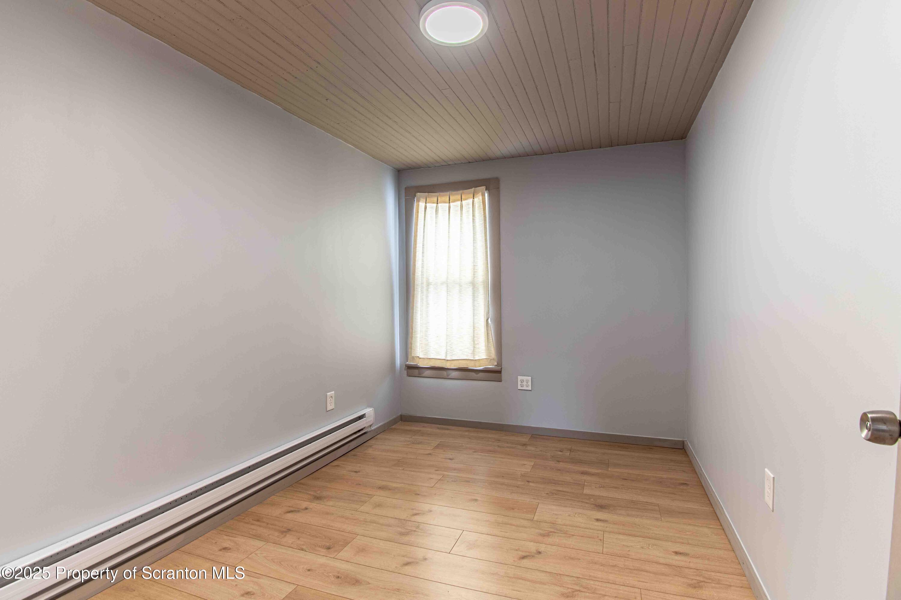 540 North Main Street Simpson, PA 18407 - Photo 10 of 17 an empty room with wooden floor and windows
