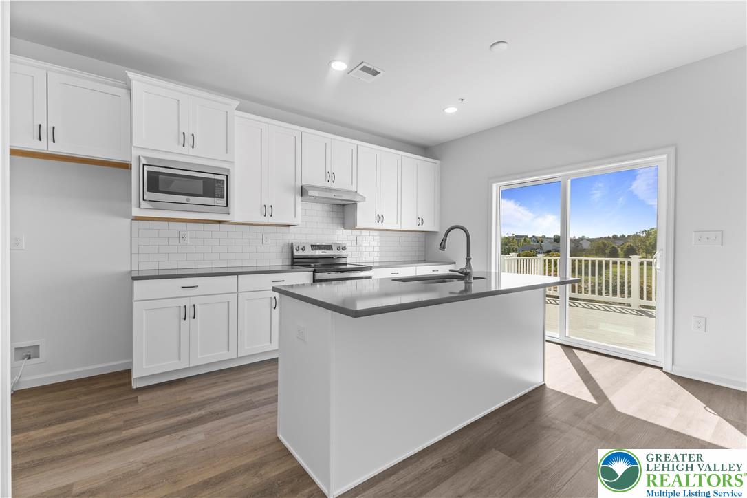 93 Timber Trail, Unit 46 Easton, PA 18045 - Photo 11 of 26 a kitchen with stainless steel appliances granite countertop a stove a sink and a microwave