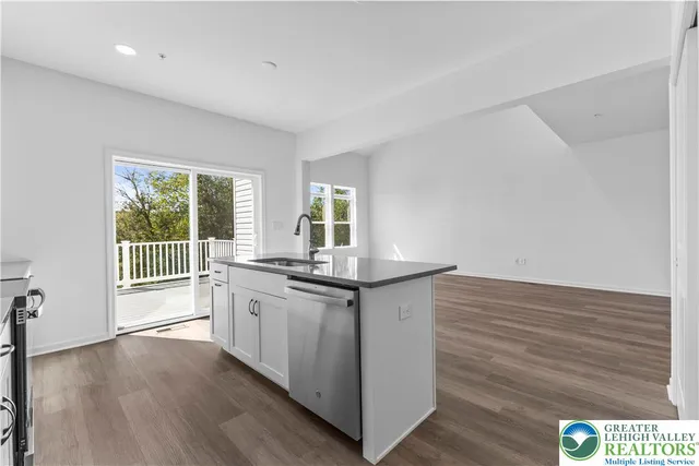 a kitchen with stainless steel appliances granite countertop a stove and a wooden floors