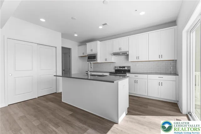 a kitchen with granite countertop white cabinets and white appliances