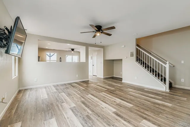 a view of a livingroom with wooden floor and a ceiling fan