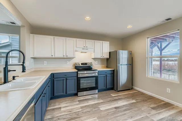 a kitchen with stainless steel appliances granite countertop a refrigerator sink and stove