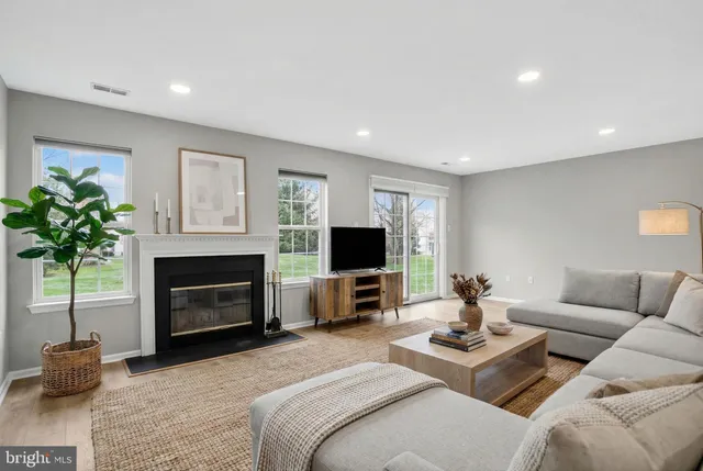 an empty room with windows and fireplace