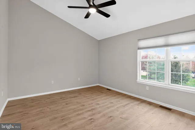 a view of a livingroom with wooden floor staircase and a kitchen