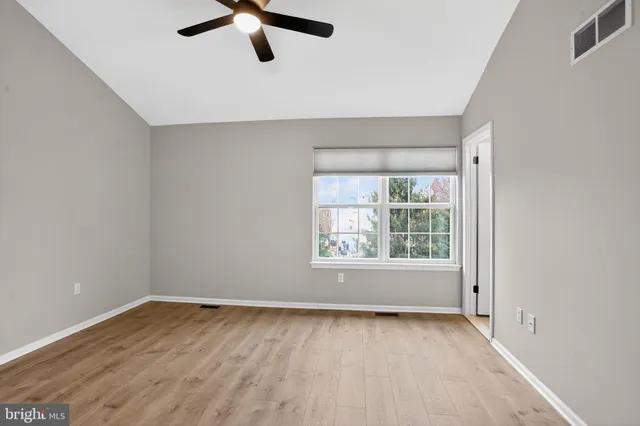 a bedroom with a bed painting on wall and a large window