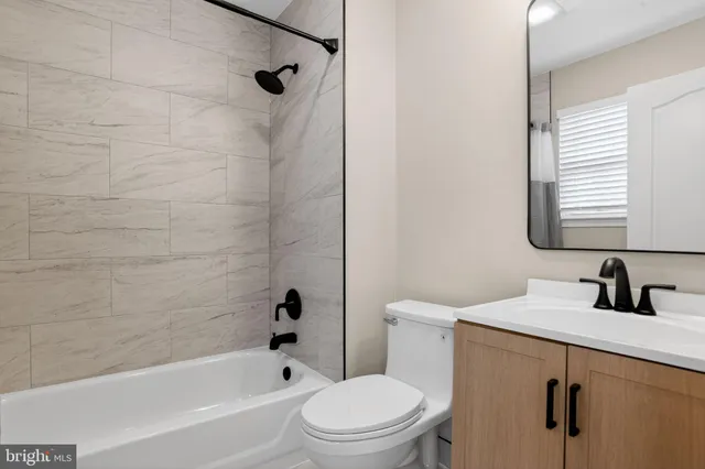 an empty room with wooden floor cabinet and windows