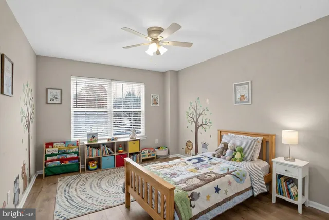 an empty room with wooden floor chandelier fan and windows