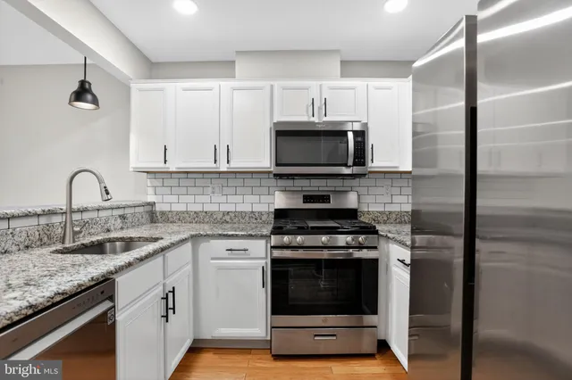 a bathroom with a granite countertop sink and a window