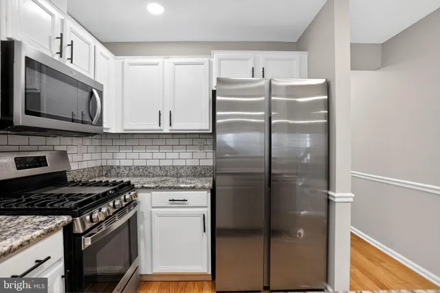 a kitchen with cabinets stainless steel appliances a sink and a stove