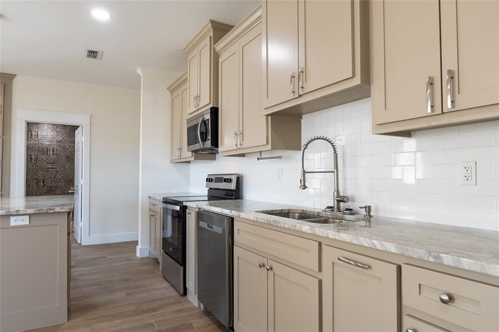 412 Crosby Street Lindale, TX 75771 - Photo 16 of 36 a kitchen with stainless steel appliances granite countertop a sink stove and cabinets