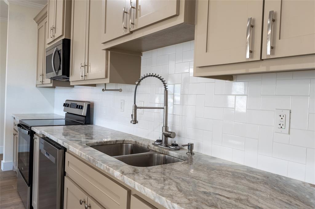 412 Crosby Street Lindale, TX 75771 - Photo 17 of 36 a kitchen with stainless steel appliances granite countertop a sink a stove and cabinets