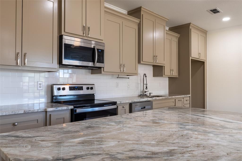 412 Crosby Street Lindale, TX 75771 - Photo 18 of 36 a kitchen with stainless steel appliances granite countertop a stove and a microwave