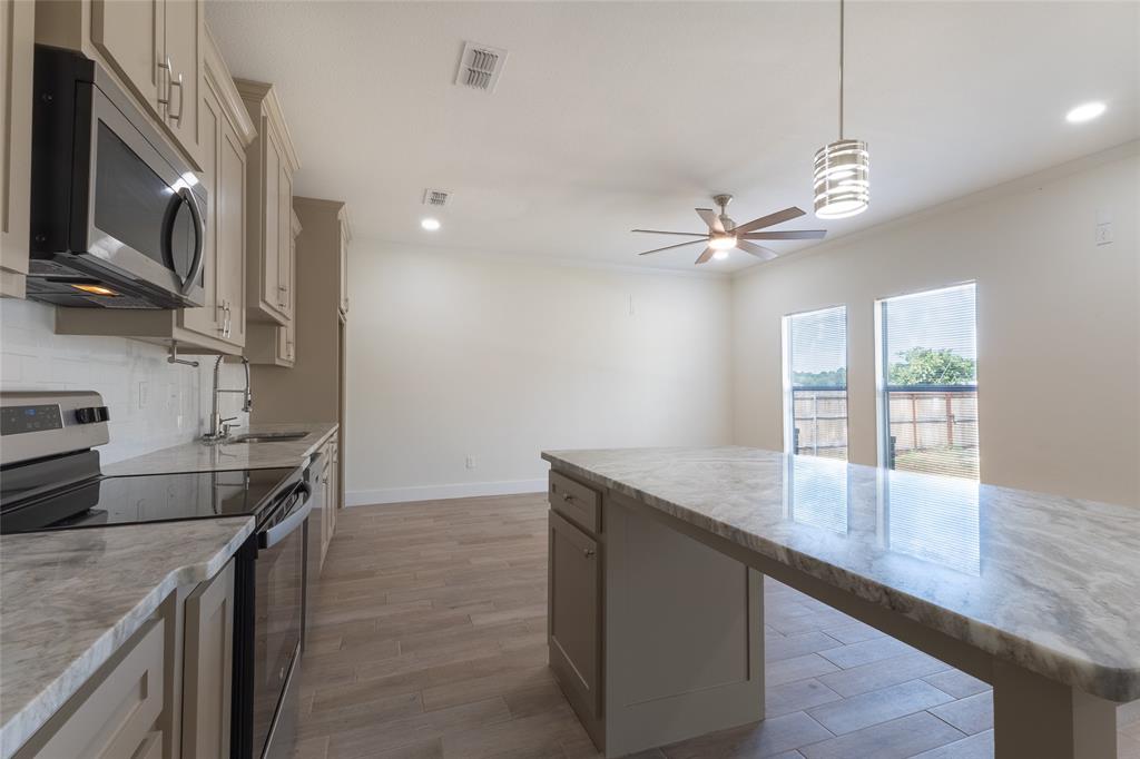 412 Crosby Street Lindale, TX 75771 - Photo 20 of 36 a kitchen with stainless steel appliances granite countertop a sink a stove and a oven