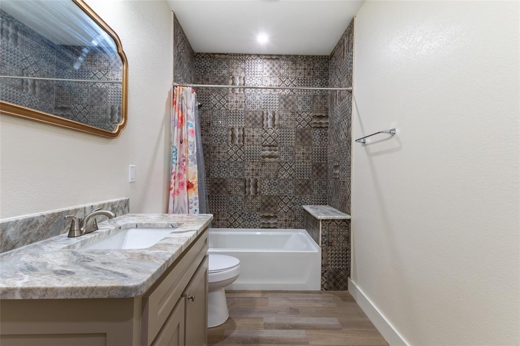 412 Crosby Street Lindale, TX 75771 - Photo 22 of 36 a bathroom with a granite countertop sink a toilet and shower