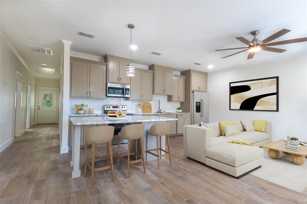 412 Crosby Street Lindale, TX 75771 - Photo 9 of 36 a living room with stainless steel appliances kitchen island granite countertop furniture and a wooden floor