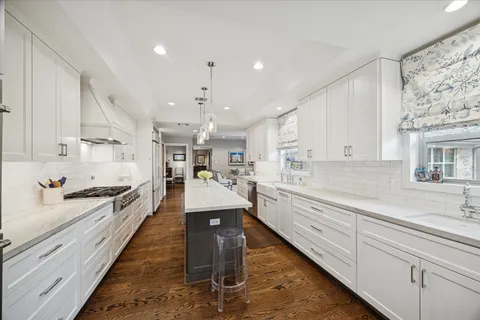 a large kitchen with stainless steel appliances kitchen island granite countertop a large counter top a stove and a sink