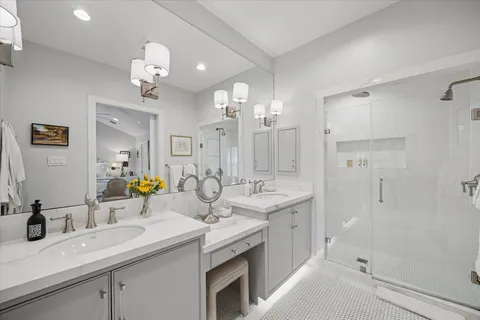 a bathroom with a sink double vanity granite tub shower and a mirror