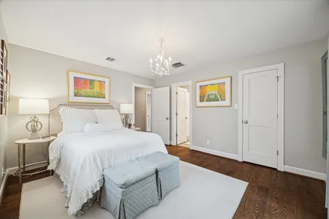 a spacious bedroom with a bed and a chandelier