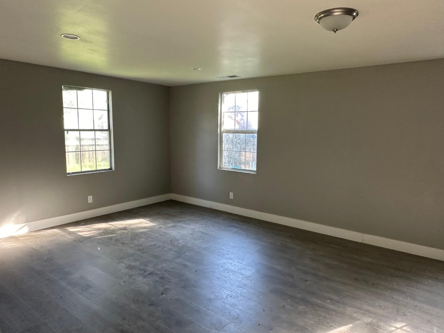 14055 River Road Walnut Grove, CA 95690 - Photo 12 of 55 an empty room with wooden floor and windows