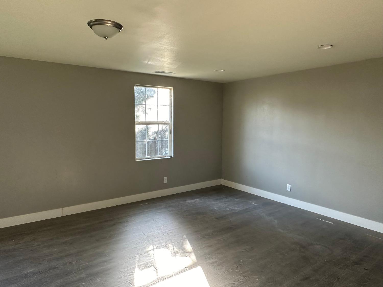 14055 River Road Walnut Grove, CA 95690 - Photo 14 of 55 an empty room with wooden floor and windows